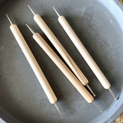 Ferramentas para modelagem com cabos de madeira clara em prato cinzento