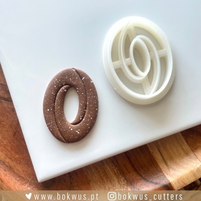 Cortador de biscoitos oval branco com biscoito marrom oval com salpicos brancos