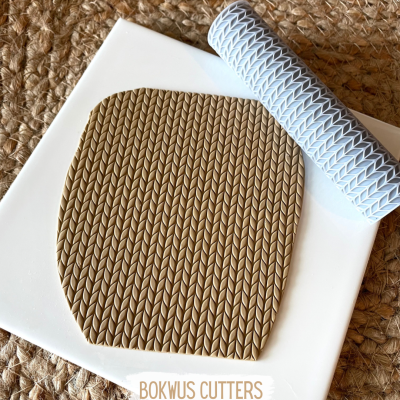 Tapete de silicone branco com massa marrom texturizada e texto BOKWUS CUTTERS