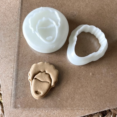 Moldes de silicone e peça moldada em forma de rosto masculino dourado