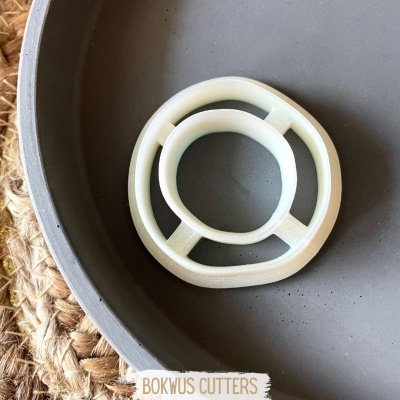 Cortador circular de massa branco dentro de uma tigela cinza