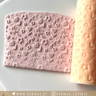 Placa de pasta de açúcar rosa com padrão floral e rolo texturizador em silicone cor de pêssego