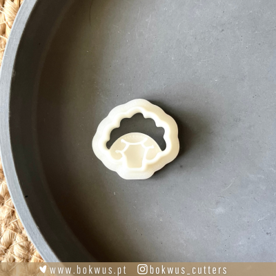 Cortante de biscoitos branco em forma de ovelha sobre superfície cinzenta