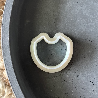 Anel de plástico branco sobre superfície preta texturizada