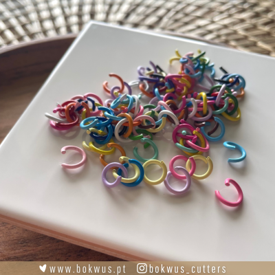 Anéis de plástico coloridos sobre prato branco e base de madeira