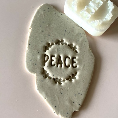 Massa cinzenta com impressão 'PEACE' e carimbo branco ao lado