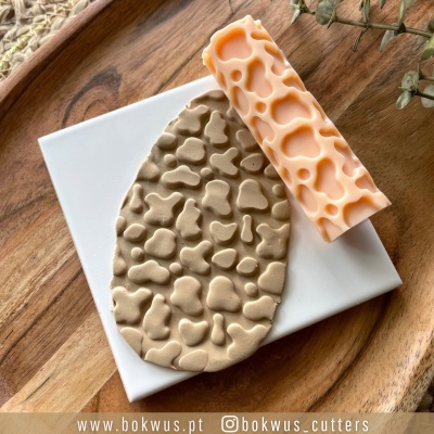 Molde e tapete texturizado em silicone bege e laranja com padrão orgânico em madeira