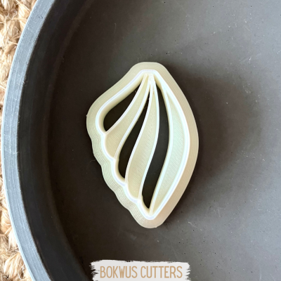 Cortante de plástico branco em formato de folha dentro de prato cinza com texto BOKWUS CUTTERS