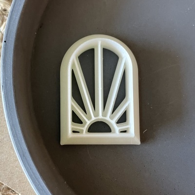 Peça decorativa branca em forma de arco com padrão de raios