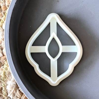 Cortador de biscoitos branco em prato preto fosco