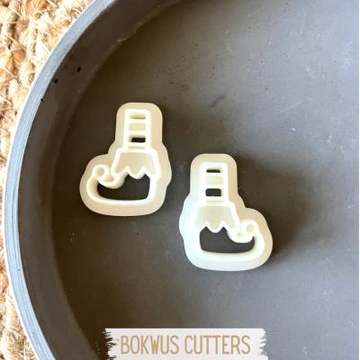 Dois cortadores em forma de bota de Natal brancos sobre prato cinzento