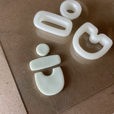 Moldes de silicone branco de vários formatos numa superfície castanha