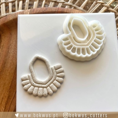 Cortador branco plástico e pastelaria dourada em superfície branca com fundo madeira