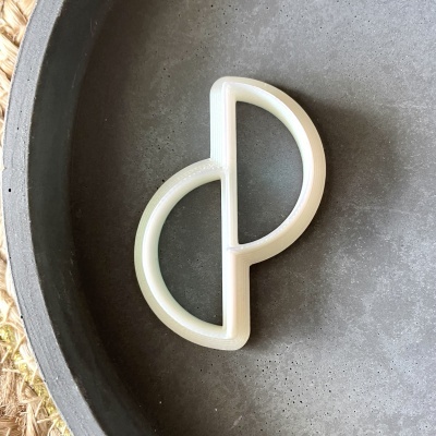 Cortador de bolachas branco translúcido dentro de uma tigela cinzenta texturizada