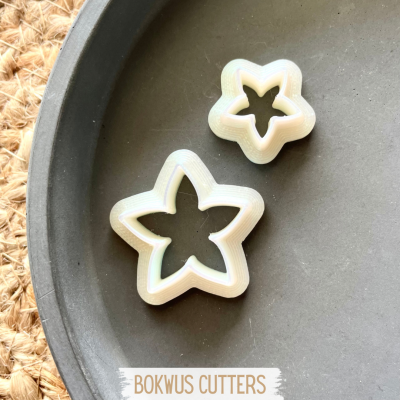 Dois cortadores de bolachas em forma de estrela sobre prato cinzento