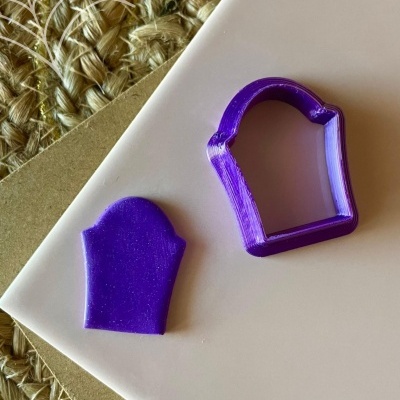 Cortador de biscoito roxo em forma de túmulo com peça cortada e etiqueta Halloween
