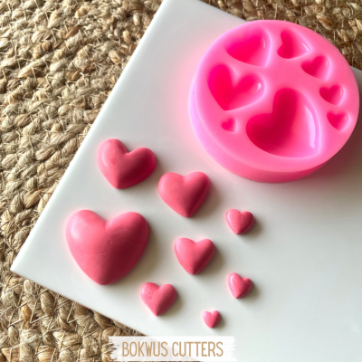 Molde de silicone rosa com corações e moldes cor-de-rosa em superfície branca