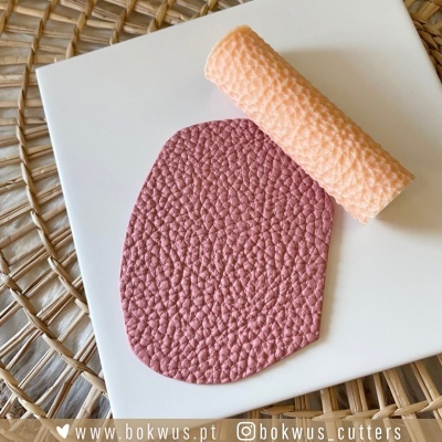 Massa castanha texturizada sobre placa branca com rolo texturizado cor de pêssego e texto www.bokwus.pt e @bokwus_cutters