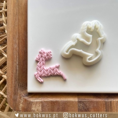 Cortador e molde de cão para massa ou fondant sobre placa branca e madeira