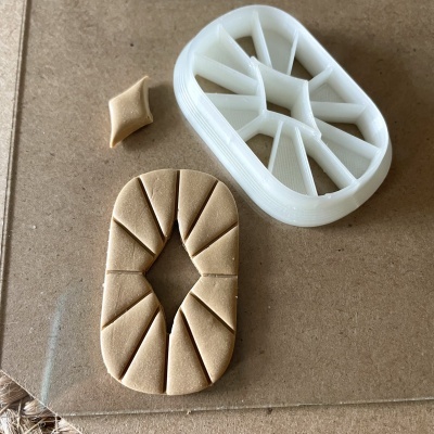 Cortador de massa branco e massa de cor bege cortada em várias partes
