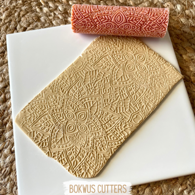 Rolo de massa com padrões gravados e placa de massa com o mesmo padrão