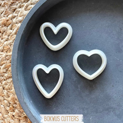 Três cortadores de coração brancos num prato preto com cartão BOKWUS CUTTERS