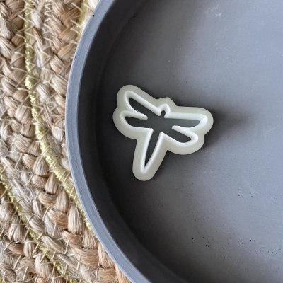 Cortador de biscoitos em forma de libélula dentro de um prato cinzento