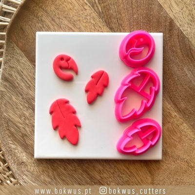 Conjunto de cortantes para bolachas em formas de folhas e flamingo em silicone rosa sobre tabuleiro branco