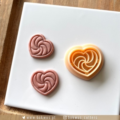 Cortante e peças em formato de coração com padrão espiral em placa branca