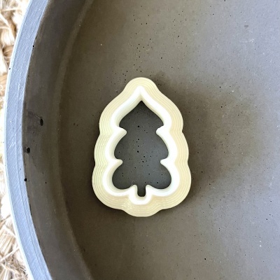 Forma de biscoito plástica branca em formato de árvore de Natal dentro de tigela cinzenta