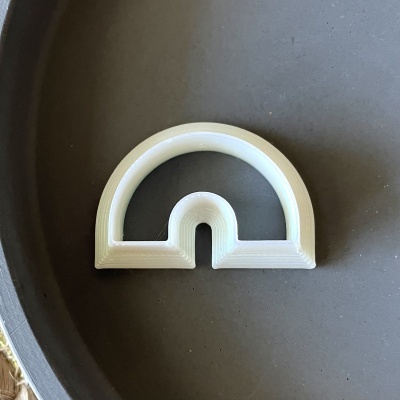 Objeto semicircular branco em superfície escura