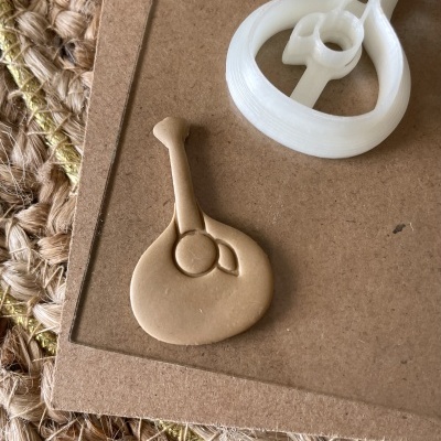 Chave de fenda em plástico branco e molde de argila marrom sobre superfície de cartão e fibra natural