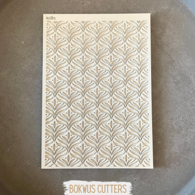 Molde de corte com padrão de folhas sobre prato cinza