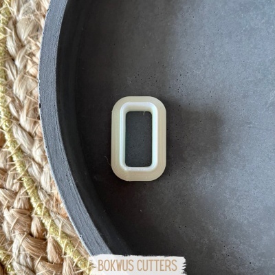 Friso retangular branco numa superfície cinzenta com etiqueta BOKWUS CUTTERS