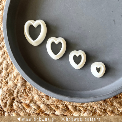 Conjunto de quatro cortadores em forma de coração branco em bandeja cinza