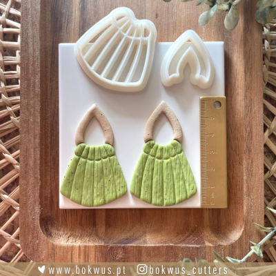 Moldes para cortar massa e brincos artesanais verde e bege sobre tábua de madeira com régua dourada