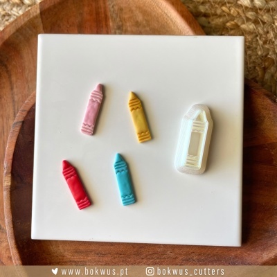 Peças coloridas em forma de lápis sobre superfície branca e tábuas de madeira