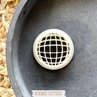 Cortante BOKWUS CUTTERS em plástico branco com padrão de grelha circular