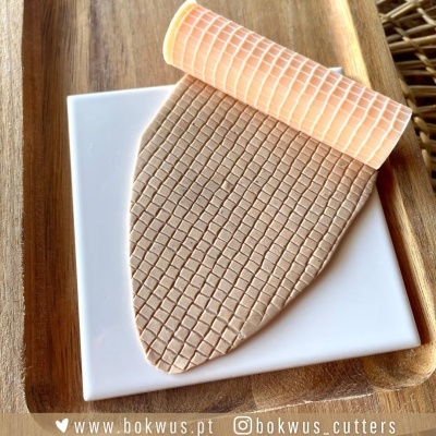 Tapete de silicone texturizado marrom claro e bege sobre prato branco e bandeja de madeira