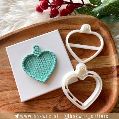 Conjunto de cortantes de coração em plástico branco com molde azul texturizado, bandeja de madeira, decoração de folhas verdes e bagas vermelhas