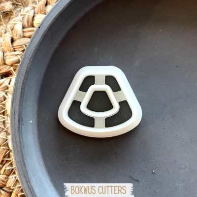 Cortador de plástico branco em prato preto com tapete de fibra natural ao fundo