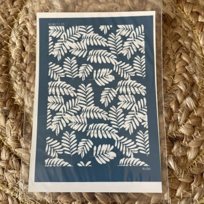 Cartaz com padrão de folhas brancas em fundo azul escuro embalada em plástico