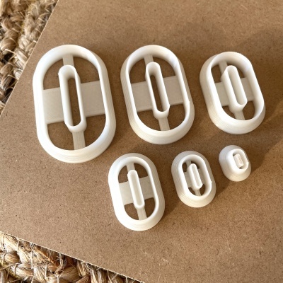 Ilhós brancos de plástico de vários tamanhos em superfície de madeira clara