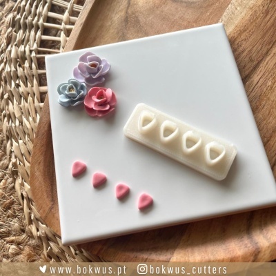 moldes para pasta ou bolachas com formatos de coração e flores em silicone sobre superfície branca
