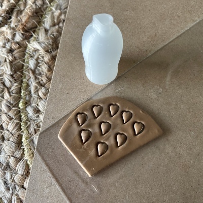 Forma de silicone branca e base castanha com corações em relevo