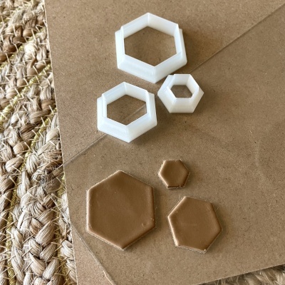 Formas hexagonais brancas e peças de bolacha marrons sobre superfície castanha e tapete de fibras naturais