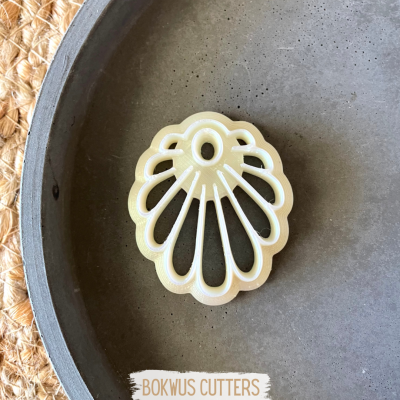 Cortador de bolachas em forma de concha num prato cinza