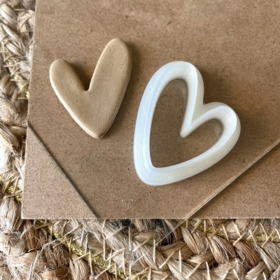 Dois corações em materiais diferentes sobre papel castanho e tapete de fibras naturais