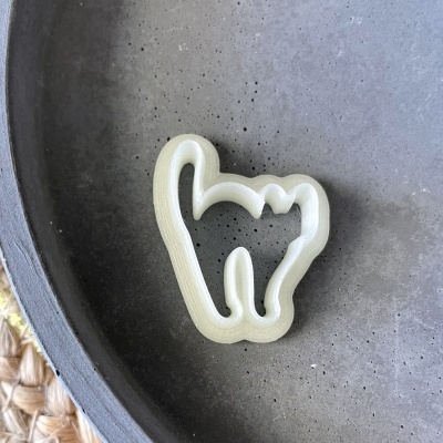 Forma de cortar biscoitos em formato de gato sobre prato cinzento