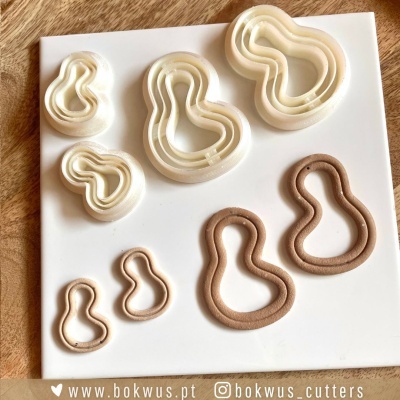 Conjunto de cortadores de biscoitos e argila polimérica em formatos orgânicos sobre placa branca